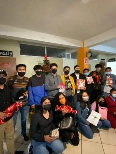 Grupo con cubrebocas en intercambio navideño